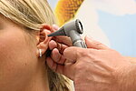 Ein Ohr wird mit einem Instrument untersucht.