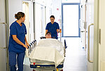 Zwei Pflegerinnen schieben ein Bett mit einem Patienten über den Flur der Zentralen Notaufnahme des St. Martinus-Hospitals Olpe.
